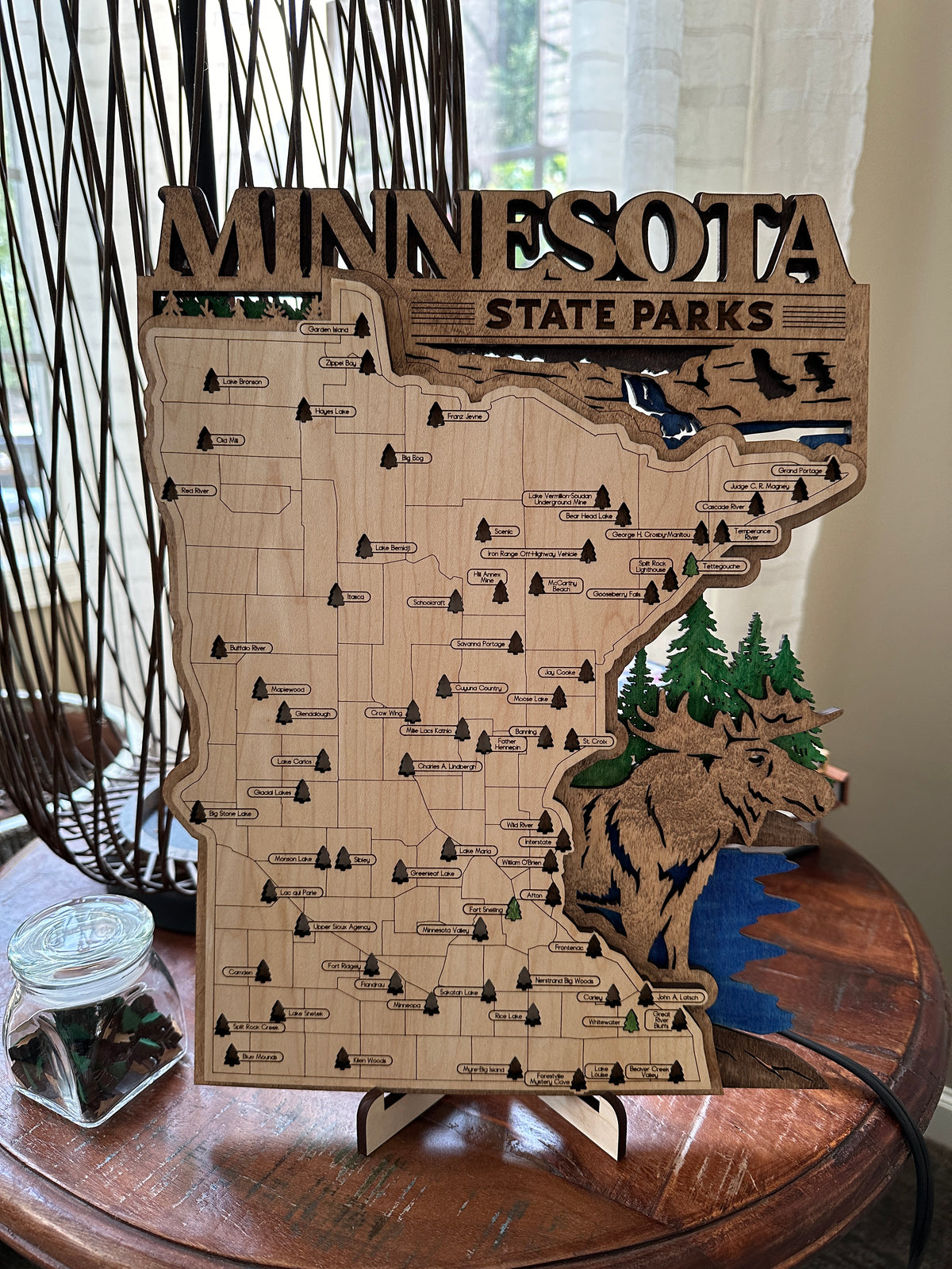 Wooden map of Minnesota State Parks on a decorative stand.